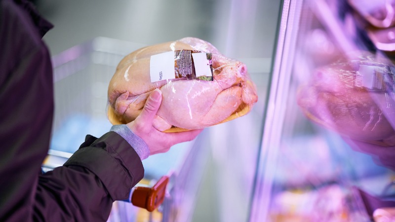 femme choisissant du poulet au supermarché